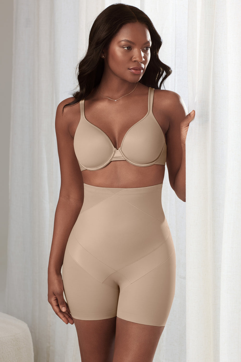 a black lace hipster panty, a rose pink lace hipster women's panty, and a white lace hipster women's underwear laying down on a fur blanket and suede sofa